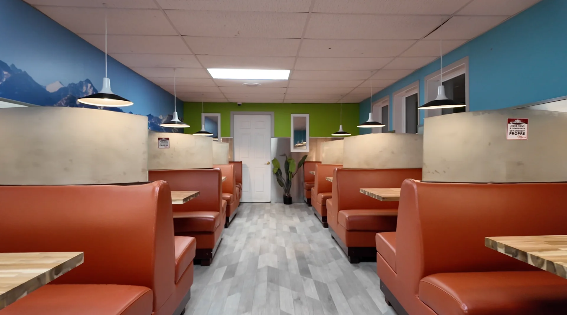 Salle à manger au 2e étage de l'Épicerie Quatre-Bourgeois avec tables et banquettes.